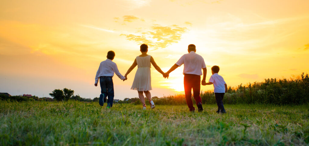Happy family on the background of the sunset
