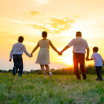 Happy family on the background of the sunset